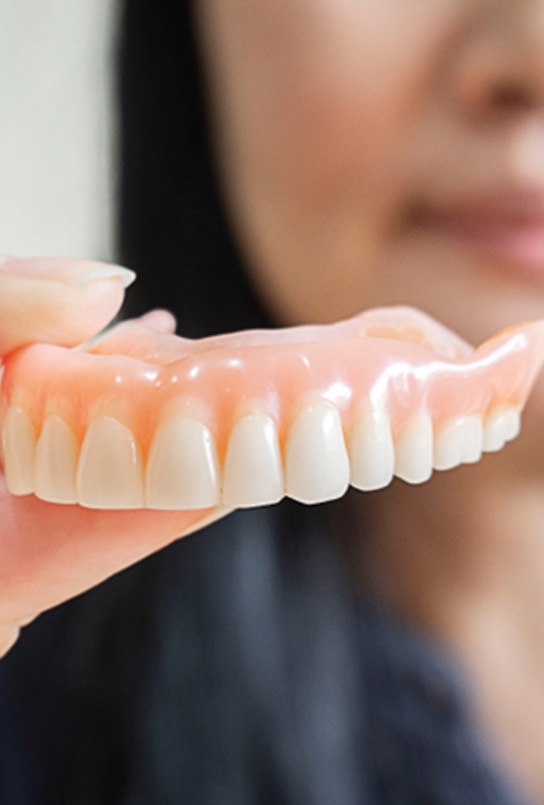 Woman holding dentures