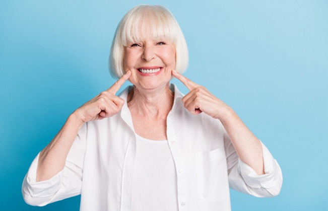 Senior woman pointing to her smile