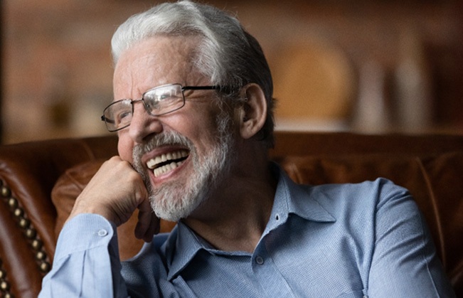 Man laughing on a leather couch