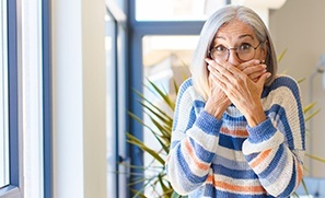 Woman with lost dental crown covering her mouth