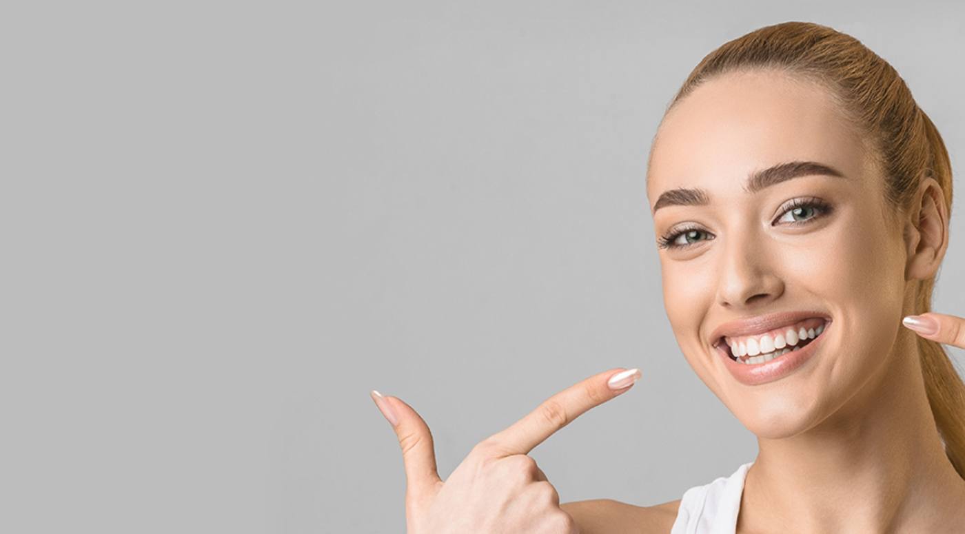 Smiling woman at dental office reception desk