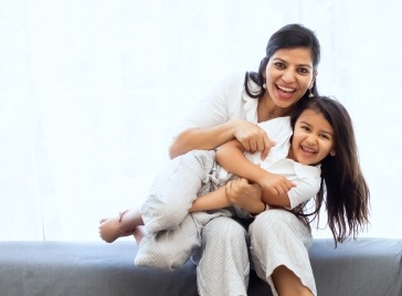 Mother and daughter laughing together after preventive dentistry visit