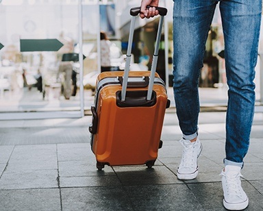 Person traveling pulling a rolling suitcase