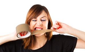 Woman using teeth to cut a piece of tape