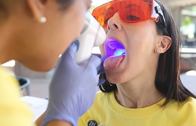 Dentist performing oral cancer screening