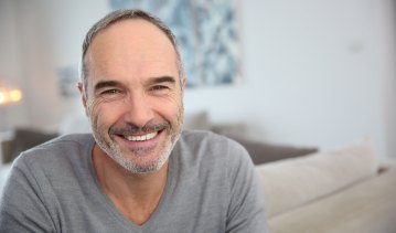 Man smiling after replacing missing teeth