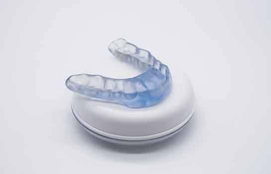 Occlusal splint resting on top of its storage container