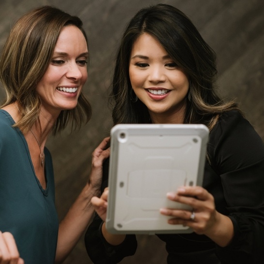 Patient and dental team member reviewing affordable dentistry plan on tablet computer