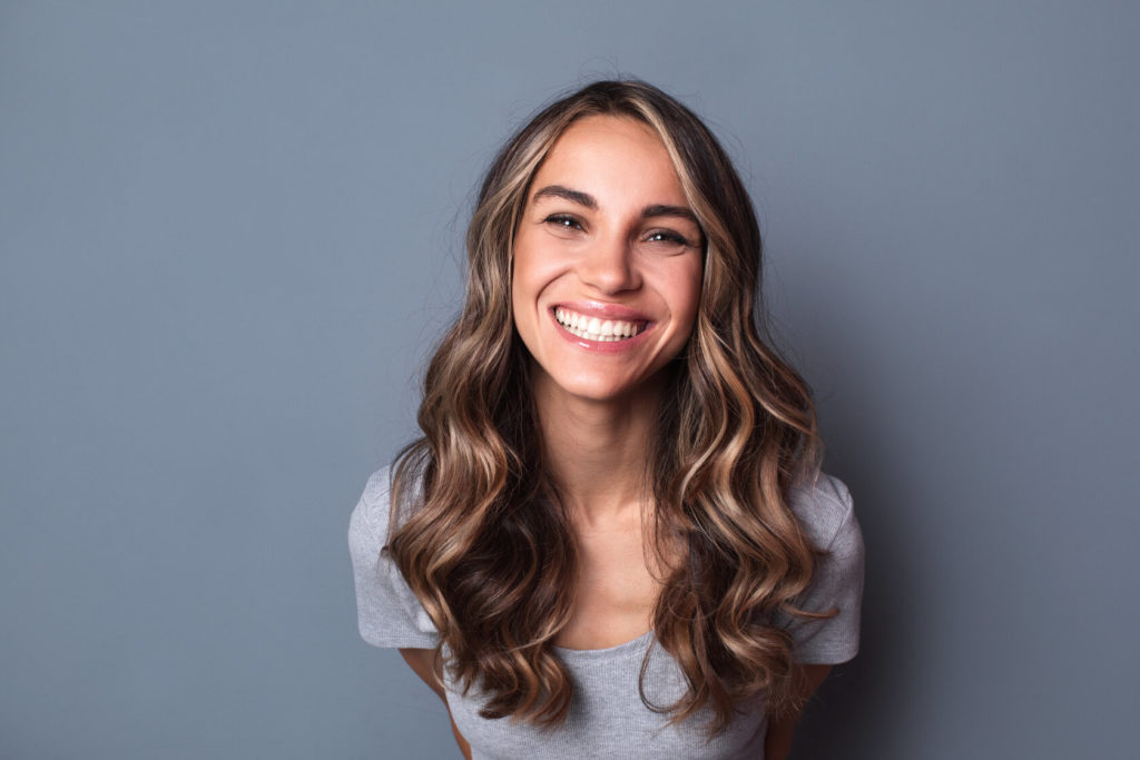 woman smiling after getting dental implants in Auburn