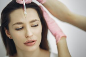 Woman receiving BOTOX in her forehead