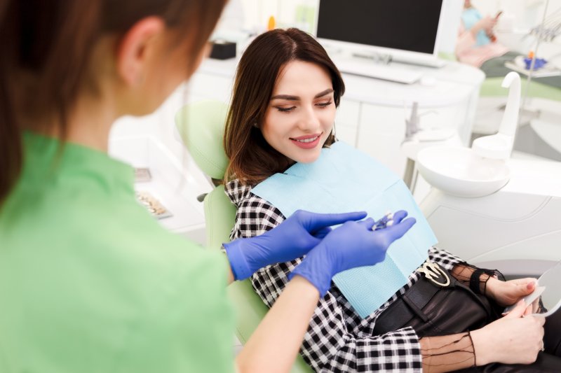 Dentist showing his patient a dental implant