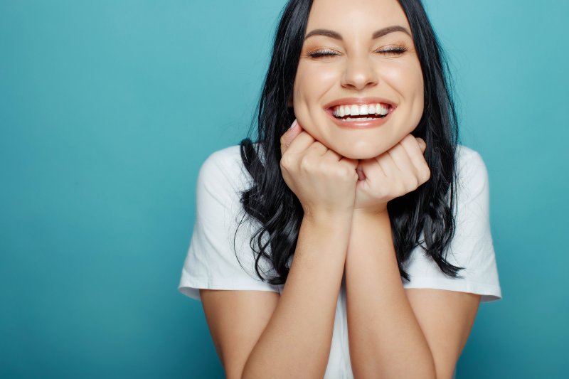 a woman smiling after fixing cosmetic dental flaws in Auburn