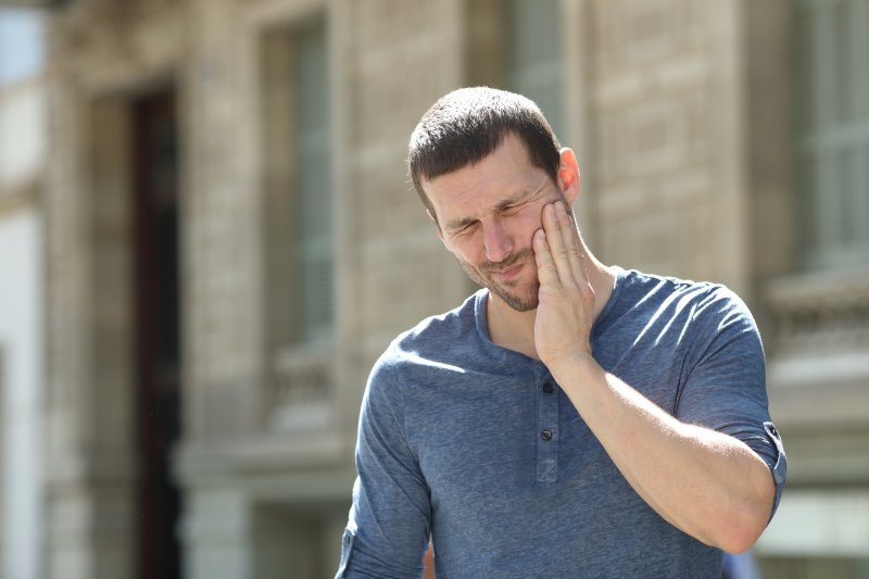 A man suffering a dental emergency that causes facial pain