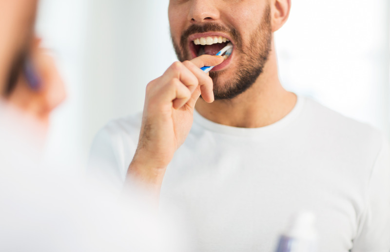 Patient brushing their teeth to prevent dental emergencies